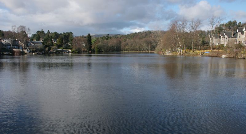 Tannoch Loch in Milngavie, with houses and trees along the far shore